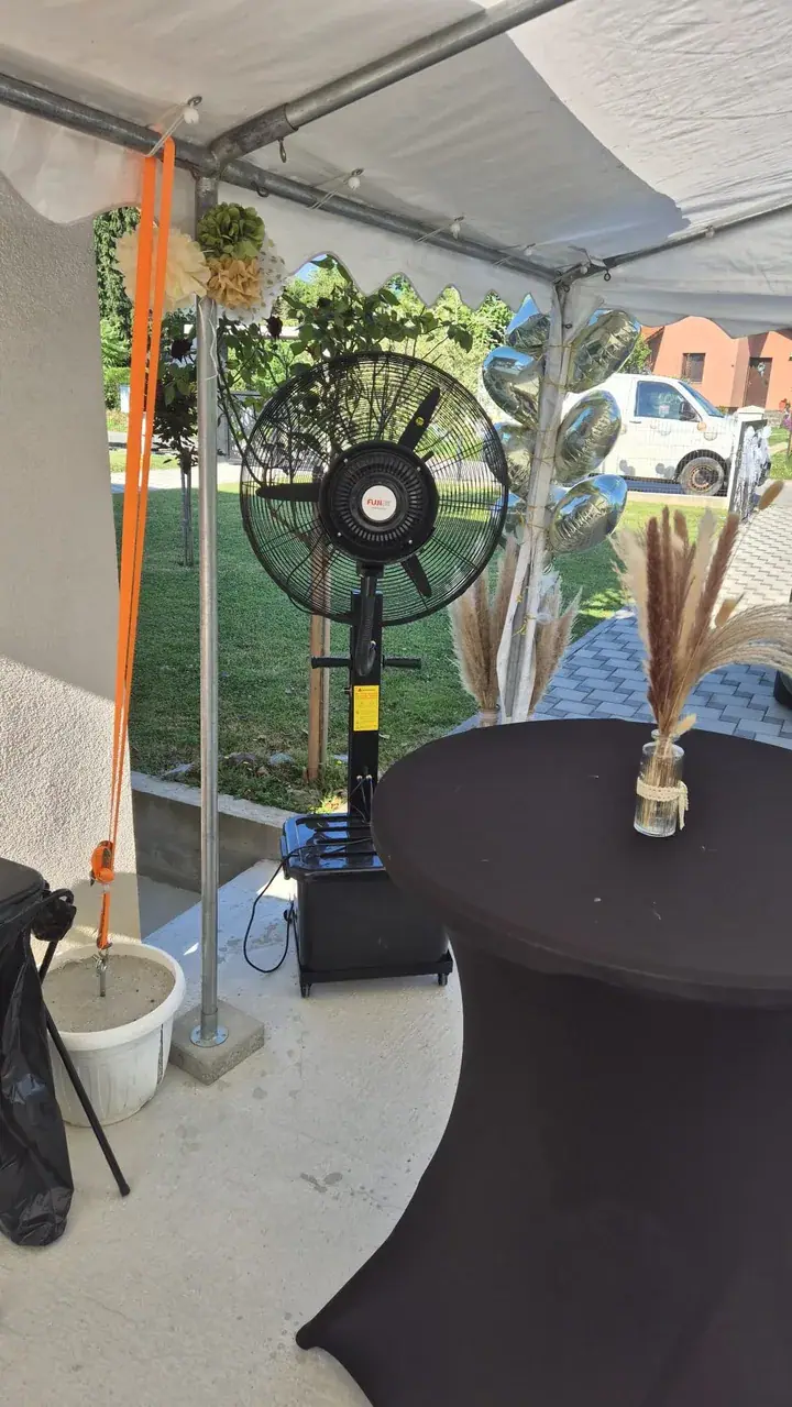 Ventilator s maglicom na natkrivenoj terasi restorana postavljenoj za svadbenu večeru